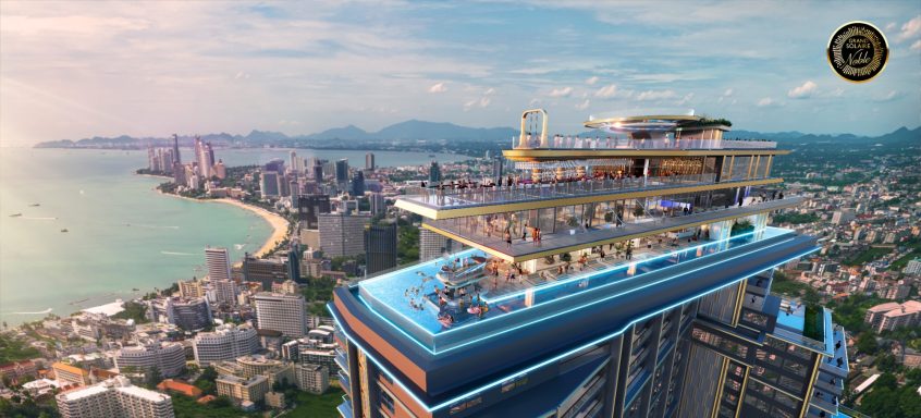 Aerial view of a modern skyscraper with a rooftop pool overlooking a city and coastline.