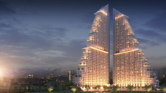 Modern skyscraper with a unique angular design, illuminated at twilight.